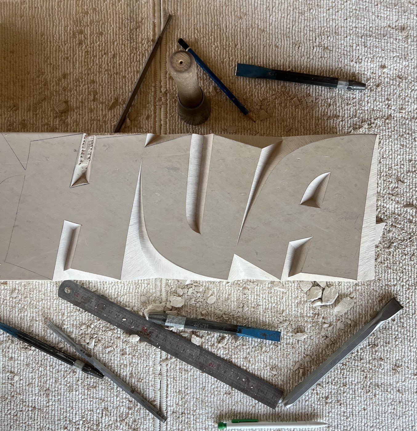 Gravure de lettres HUA en cours, outils sur l etabli